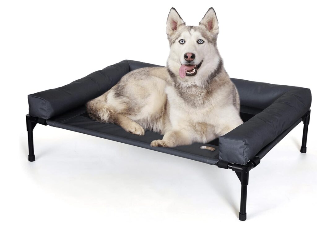A dog lying in a dark grey K&H Ortho Bolster Dog Bed
