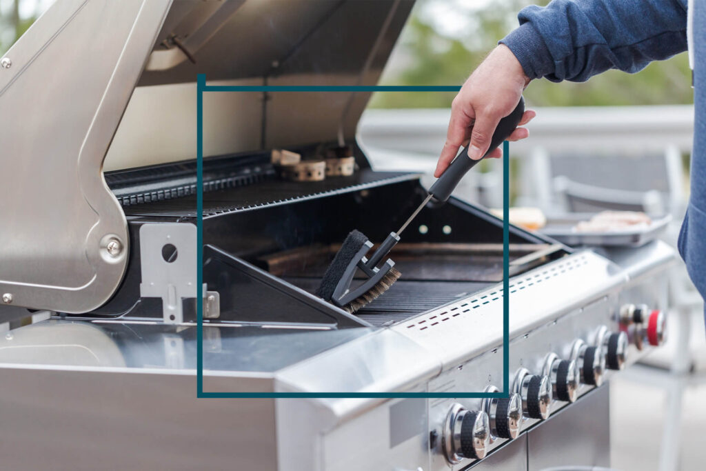 person cleaning a grill