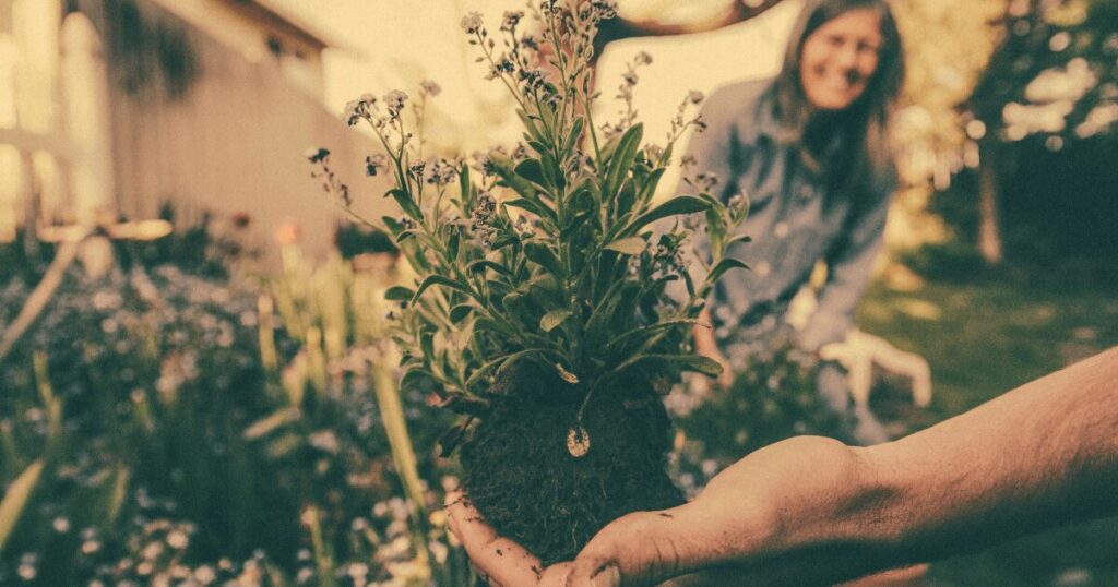 Woman laughing while working with a partner in the garden