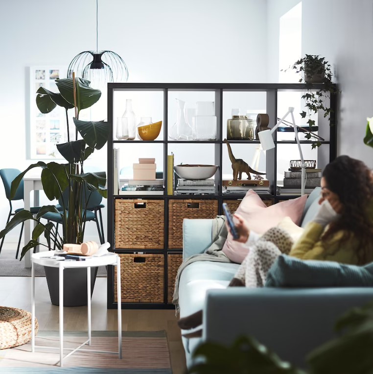 a black open shelf unit dividing an open room