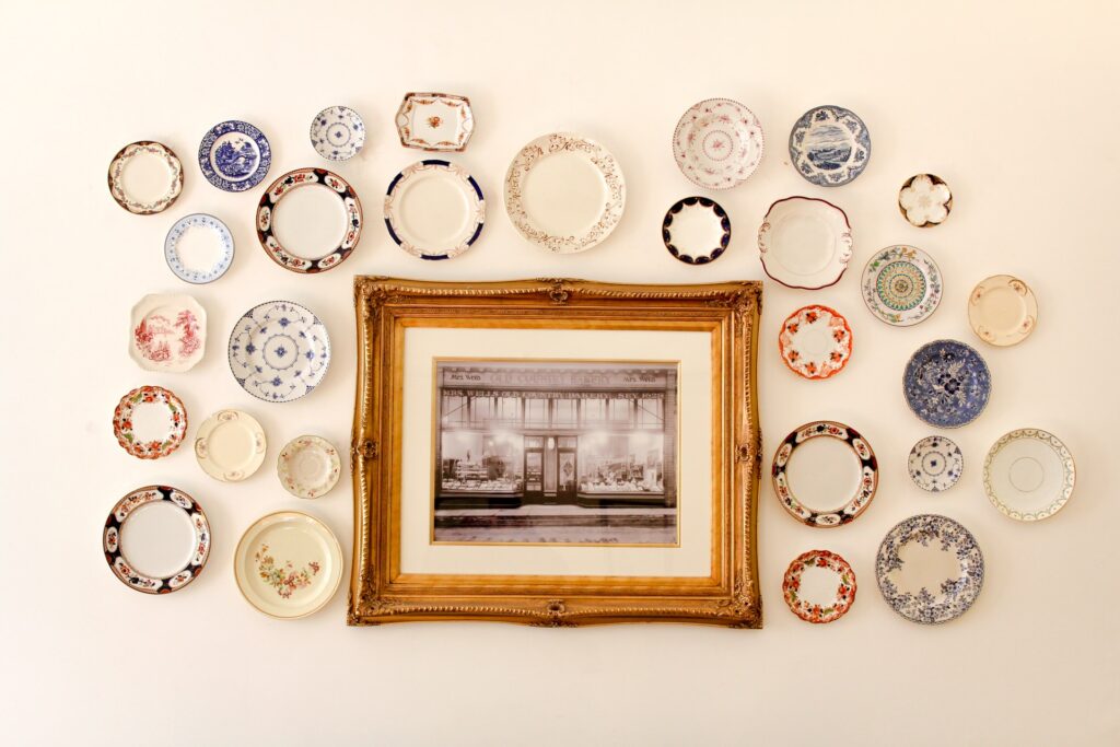 a hanging gold frame with colorful ornately decorated plates hanging on the wall
