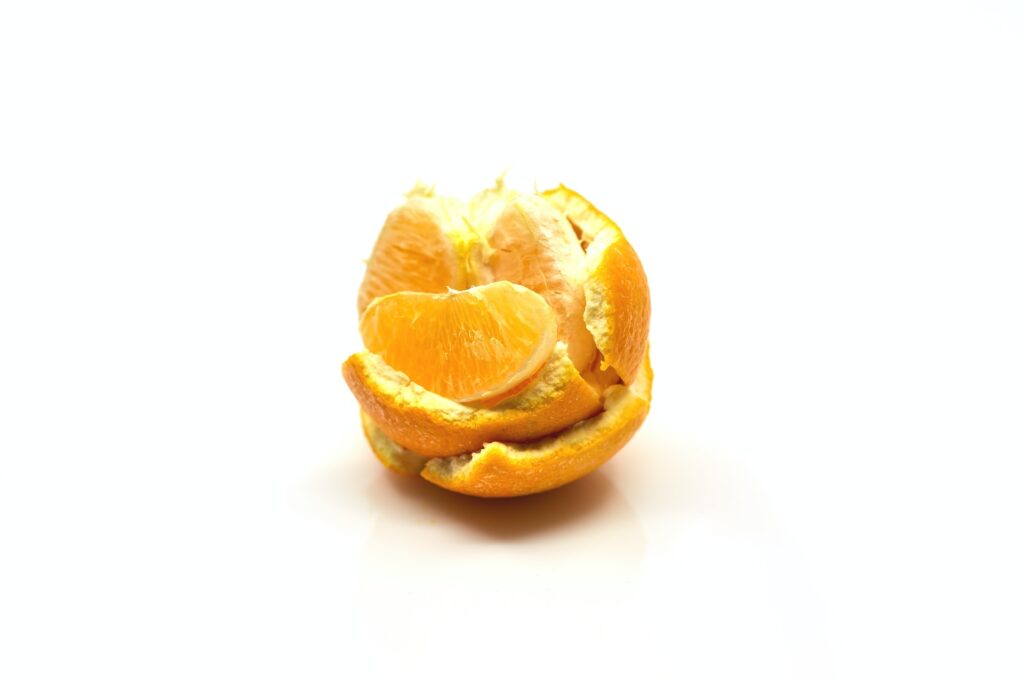 orange peels stacked with orange slice resting on it
