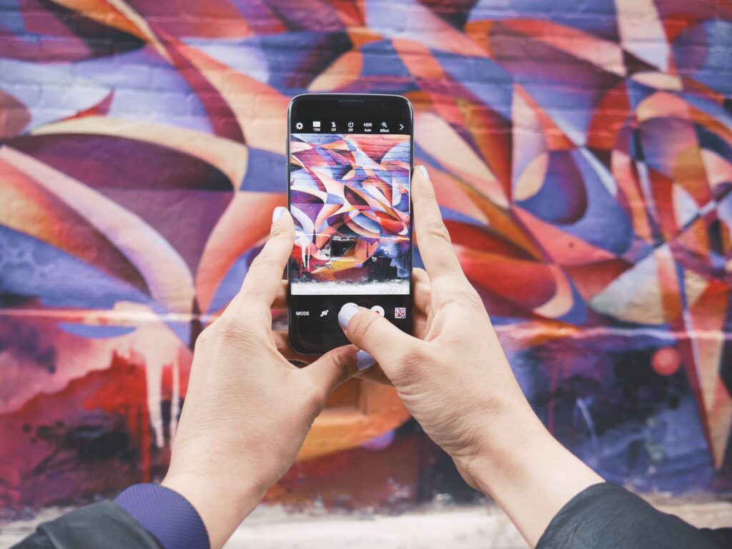 a woman taking a picture of outdoor art on her iPhone