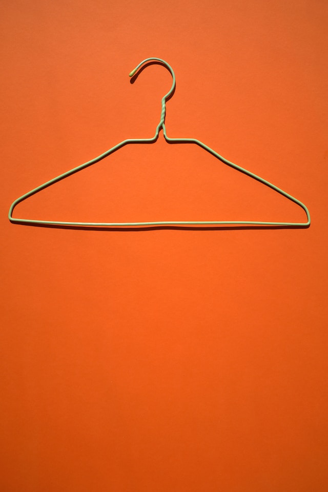 Metal hanger on orange background.
