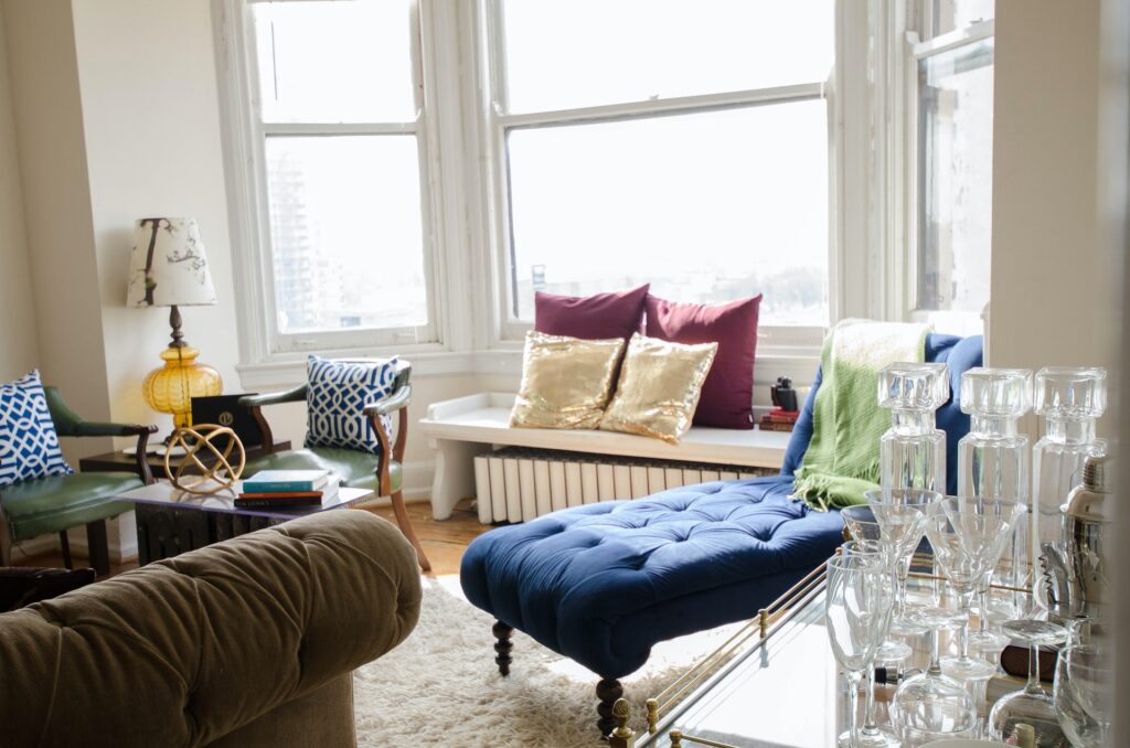A small, brightly-colored living room with a bar cart