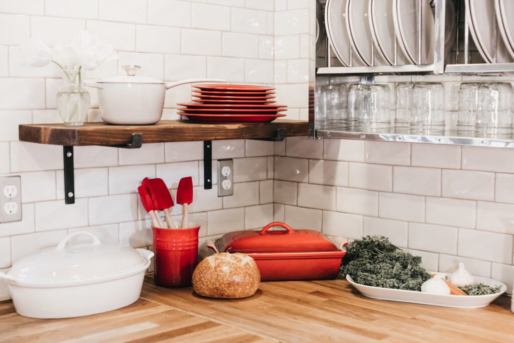 Wooden and metal shelving hung on a white tile wall