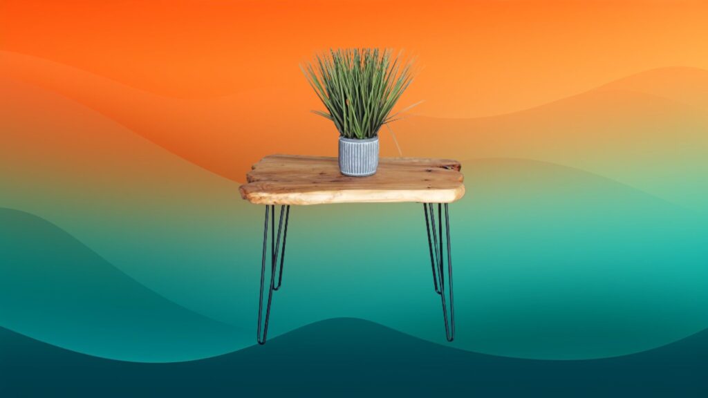 small wooden topped coffee table with black metal legs and a grass plant on top in front of an orange and teal gradient background