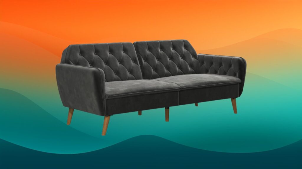 tufted dark gray couch in front of an orange and teal background