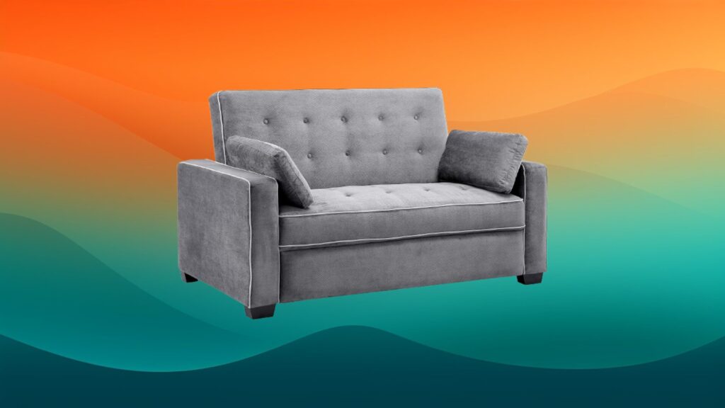 small tufted gray couch in front of an orange and teal background