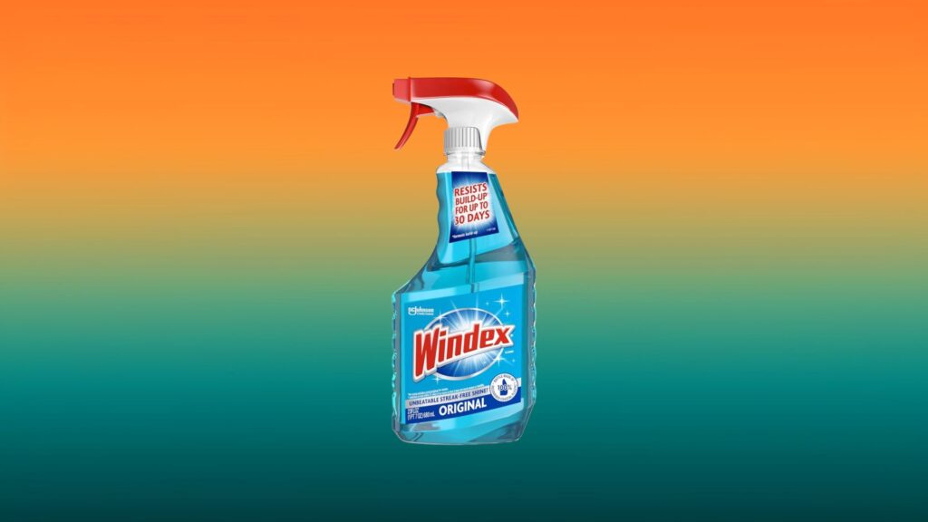 clear bottle of blue Windex with orange and teal gradient background
