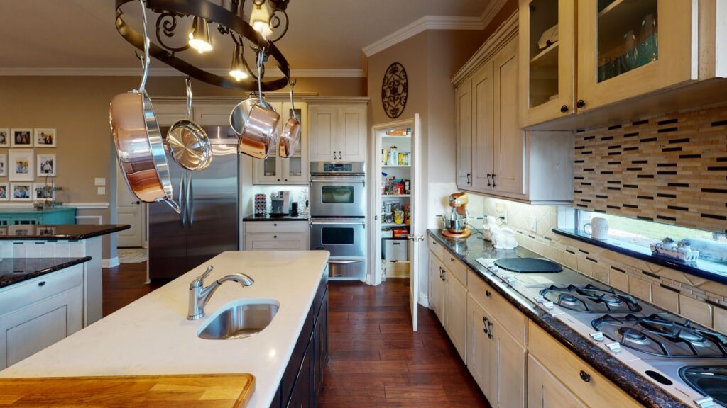 Organize kitchen cabinets with hanging pots and clear counters