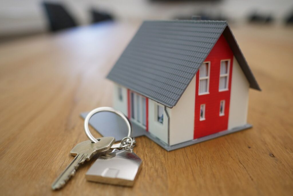 house figurine with keys sitting next to it