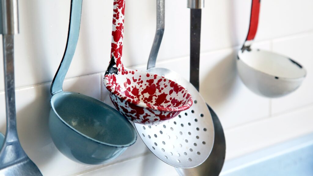 Multiple different colored ladles being hung