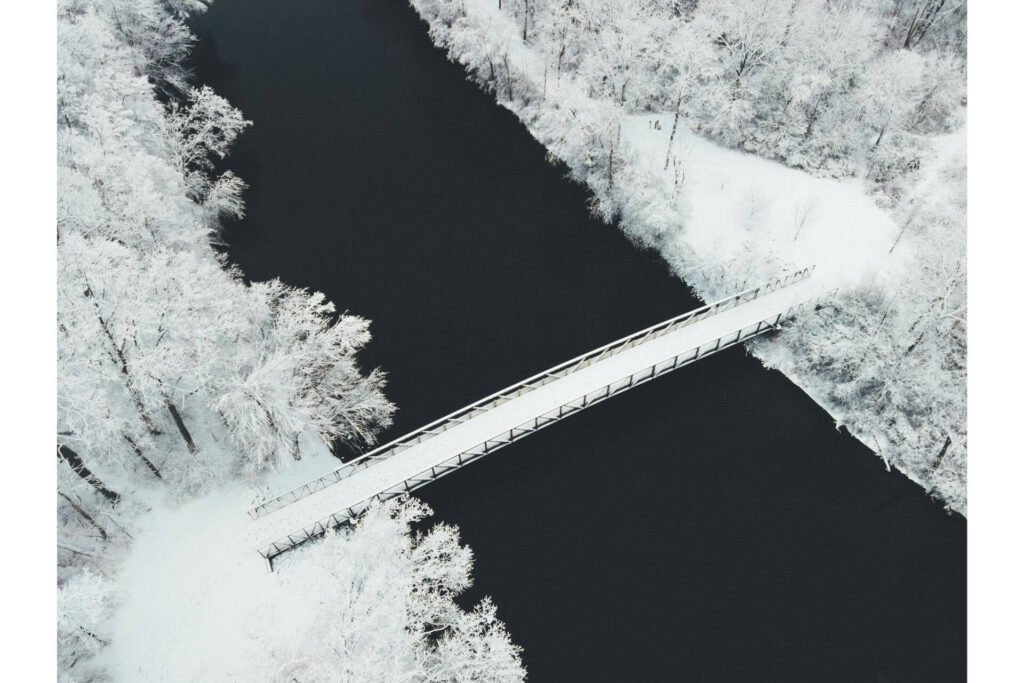 A bridge in a wooded area somewhere in Michigan covered with snow