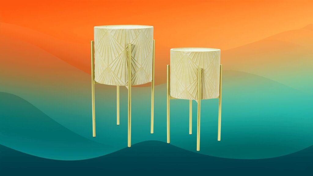 two white and gold decorative indoor flower pots in front of an orange and teal background
