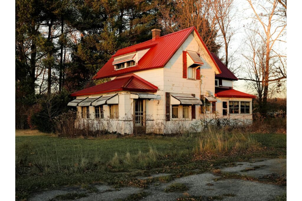 A dilapidated house with an overgrown yard tied to a zombie foreclosure.