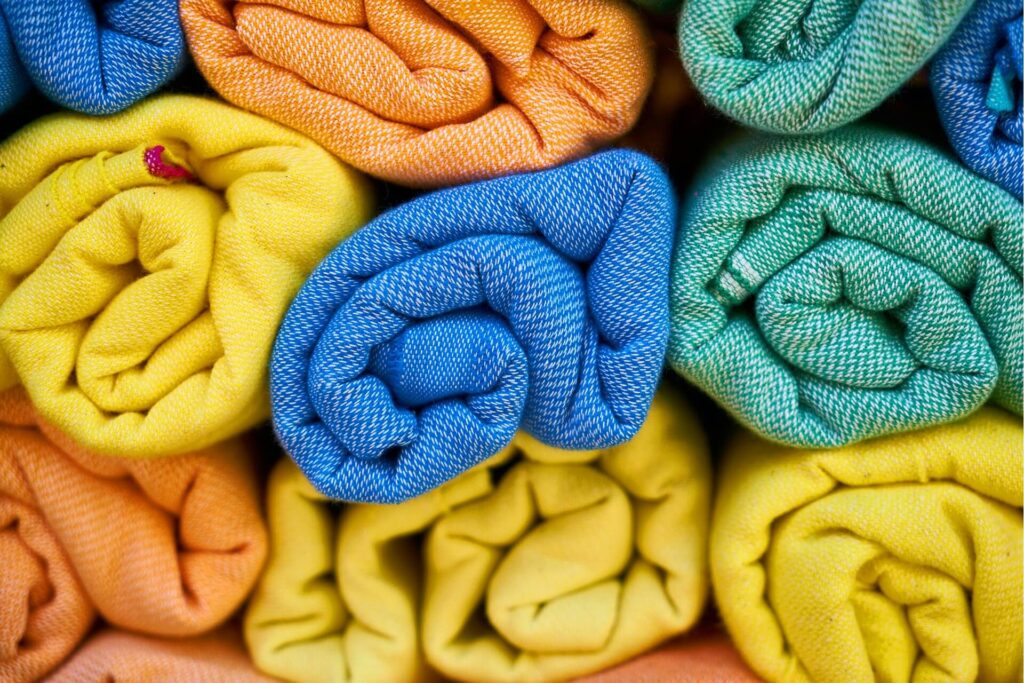 Stacks of folded towels in various colors.