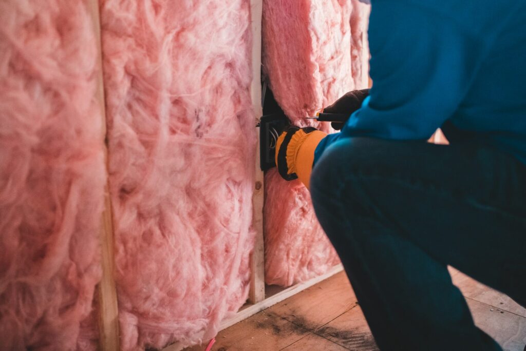 Person adding insulation to wall