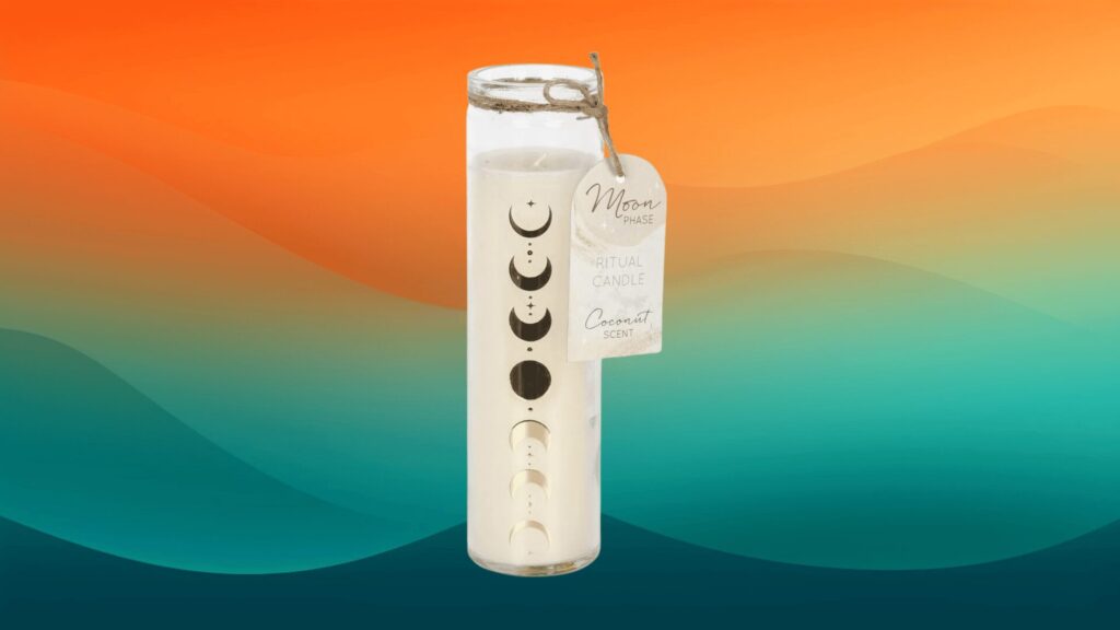 white moon phase pillar candle fall decor in front of an orange and teal background