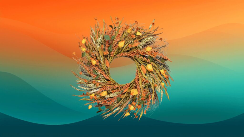fall decor wreath with leaves, flowers, and wheat in front of an orange and teal background