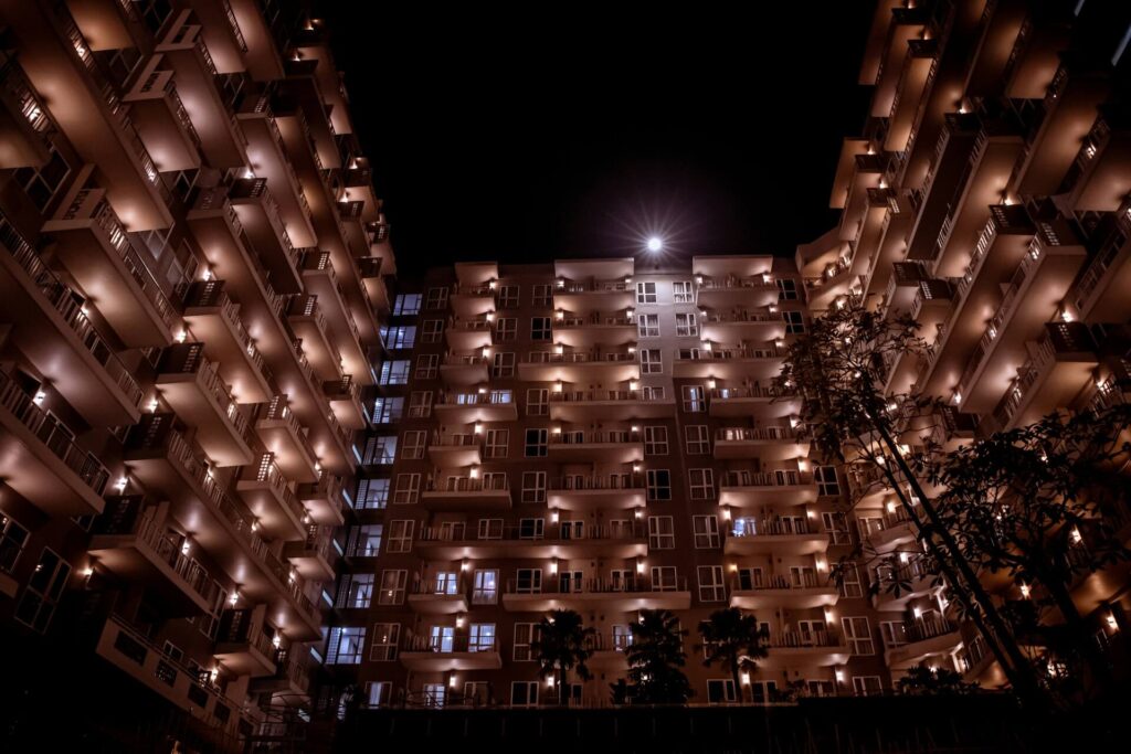 A well-lit facade of an apartment complex at night