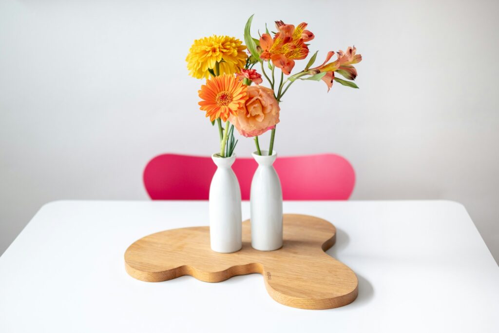 yellow and orange flowers in skinny white vases on table
