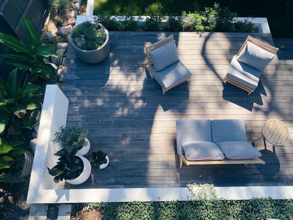 minimalist front patio for a ranch house with lots of plants in a white and grey palette