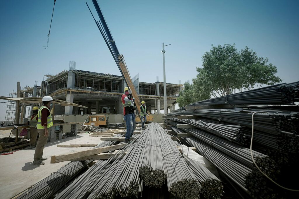 Construction workers stand on top of metal