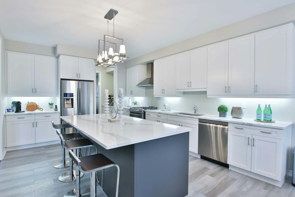 A kitchen with a simple island and white cabinetry