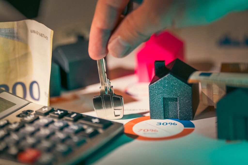 Key in the middle of house models, calculator and money