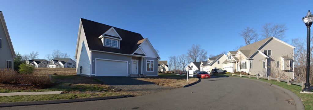 house next to road with red car