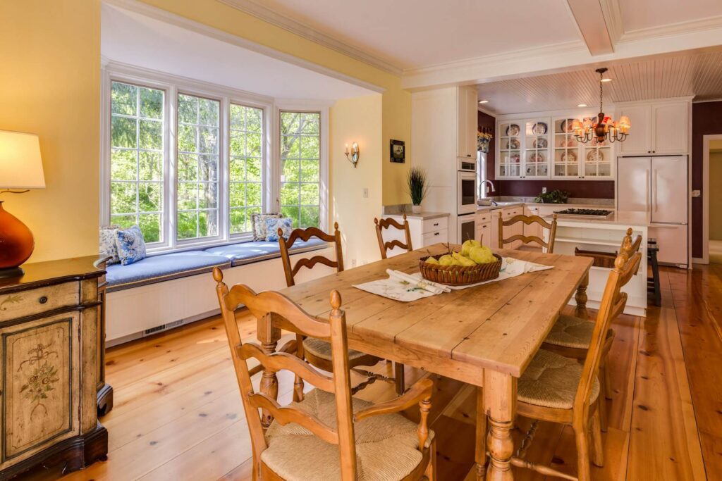 A dining area with a window seat that juts out from the wall