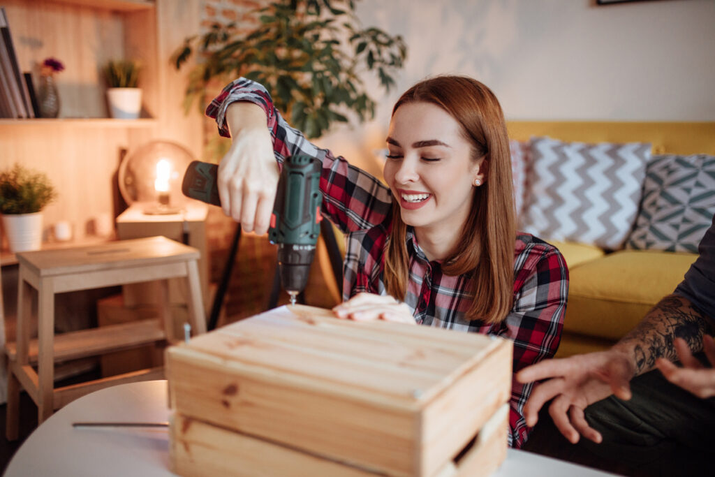 A close up of a woman using an electric screwdriver