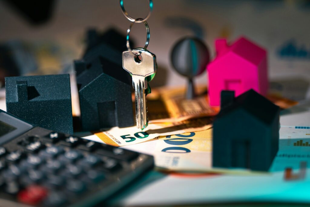 house key and mini homes near money and calculator, symbolizing home appraisal cost