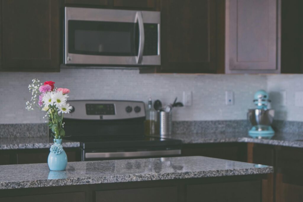A colorful vase atop a granite kitchen countertop.