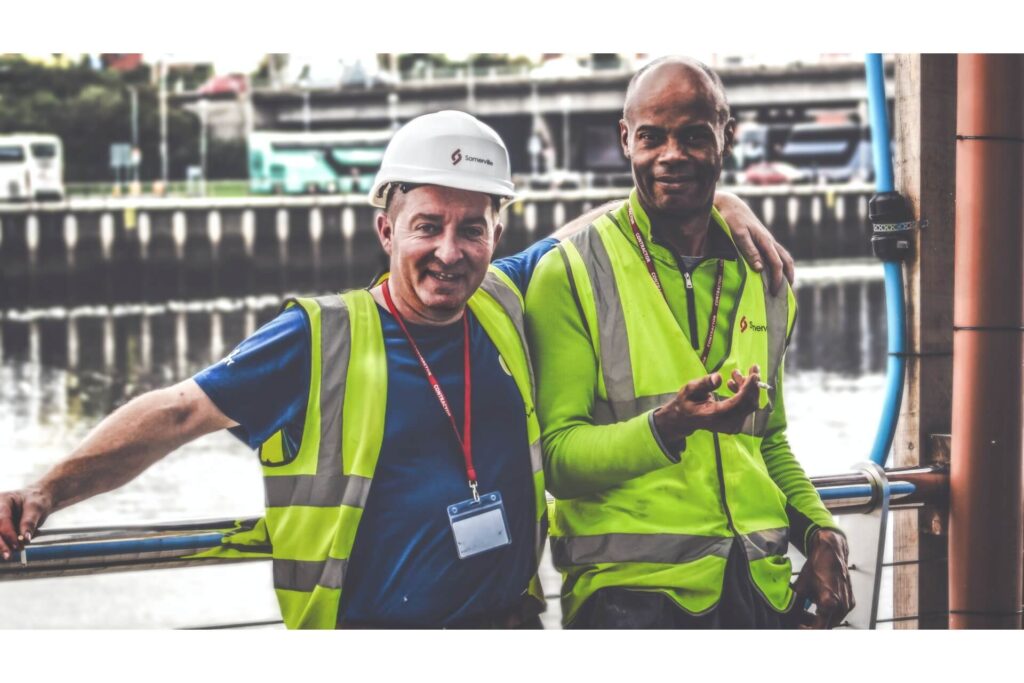 Two workers smiling during a smoke break.