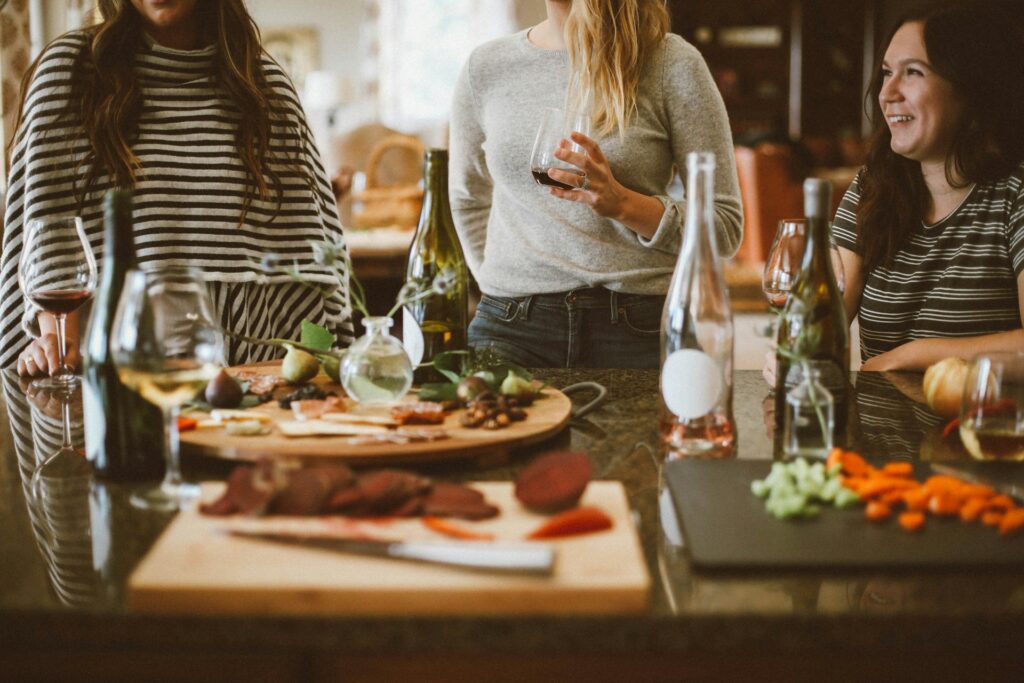 Women at a Kitchen Island With Wine and Food
