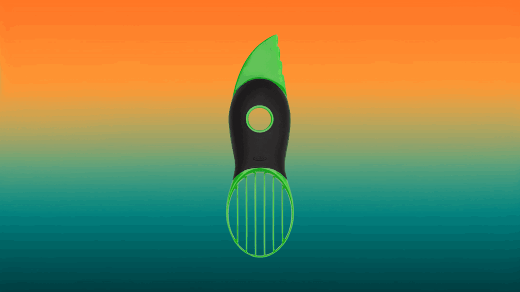 green and black avocado kitchen gadget in front of an orange and teal background