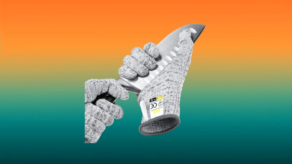 gray cutting gloves holding onto a knife in front of an orange and teal background