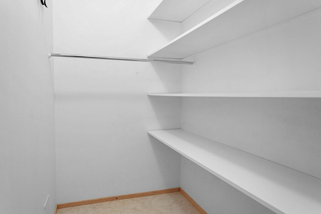 An opened, empty white closet to be turned into a mini bar design idea
