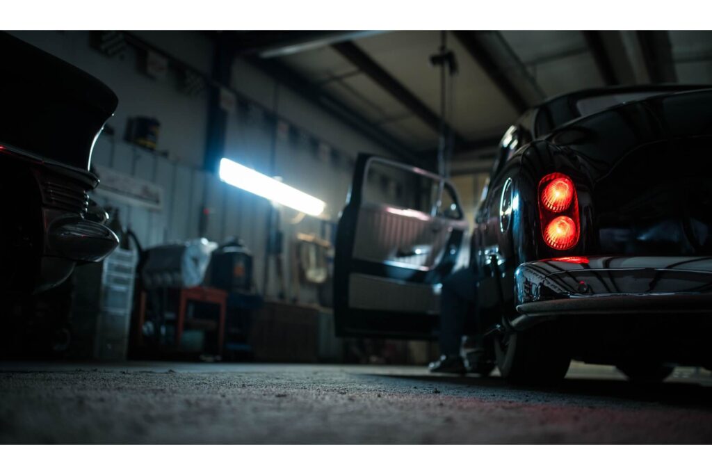 A person in an idle car inside a garage.