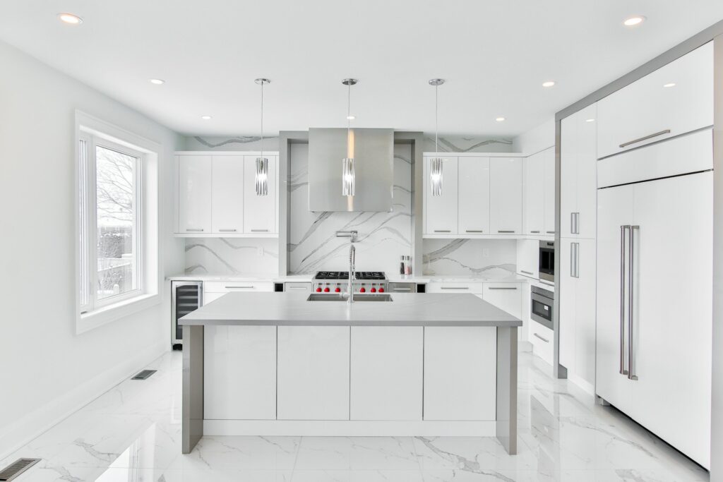 White kitchen with white cabinets and white marble floor