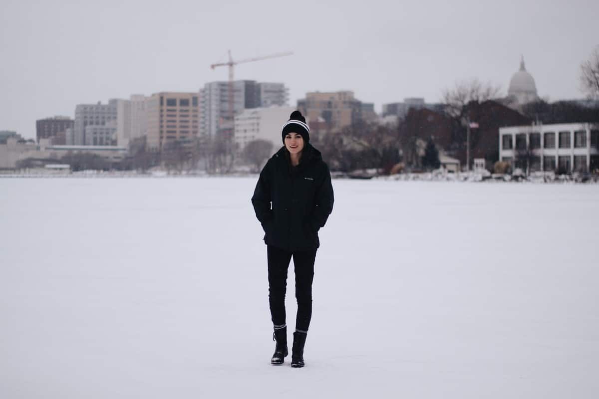 a woman standing bundled up in the snow