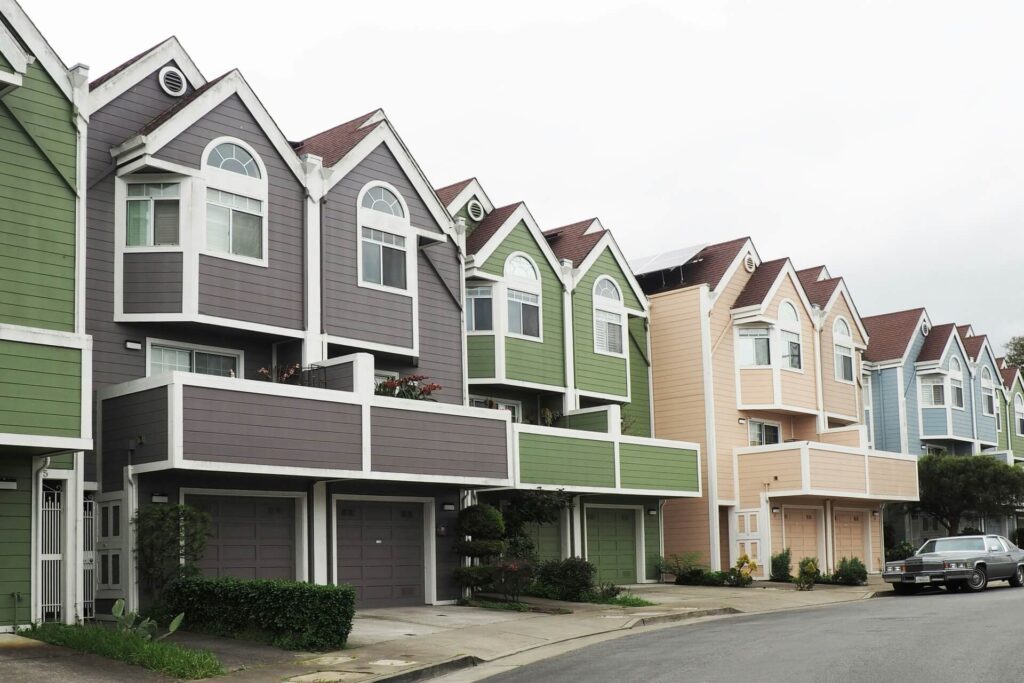 A row of houses with different vinyl siding colors.