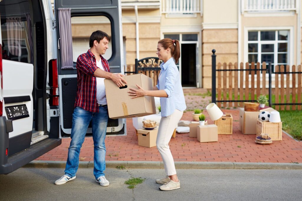 couple moving boxes from van