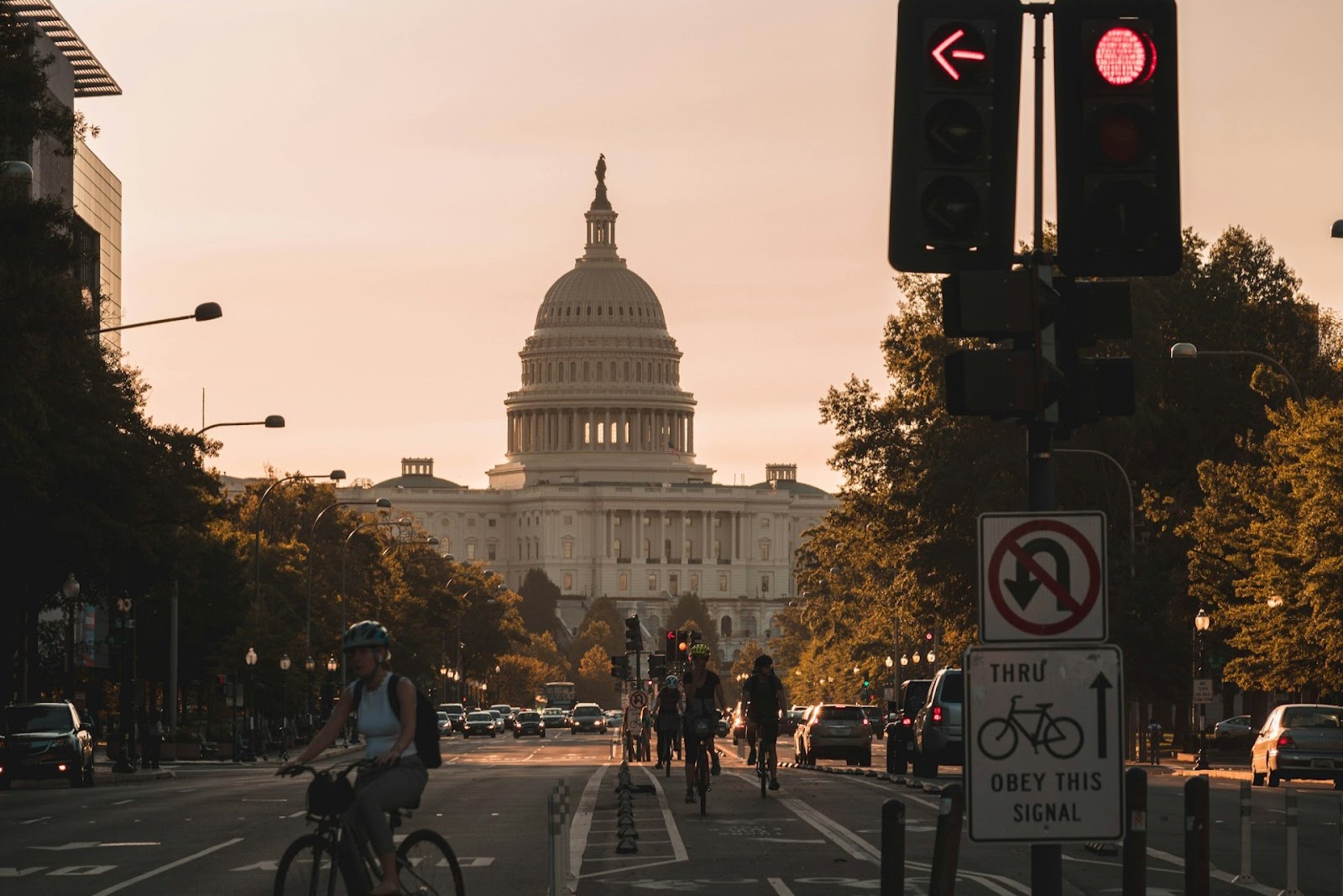 people riding bikes down the street with monument in background in one of the states with the highest cost of living