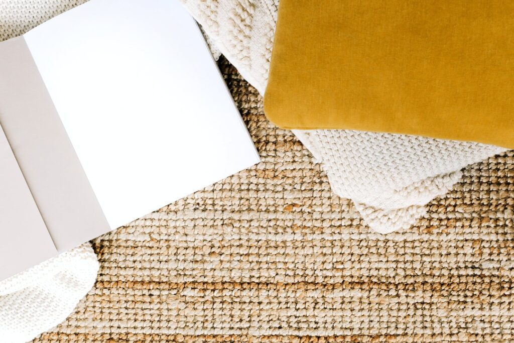 a notepad on a rug with a pillow next to it