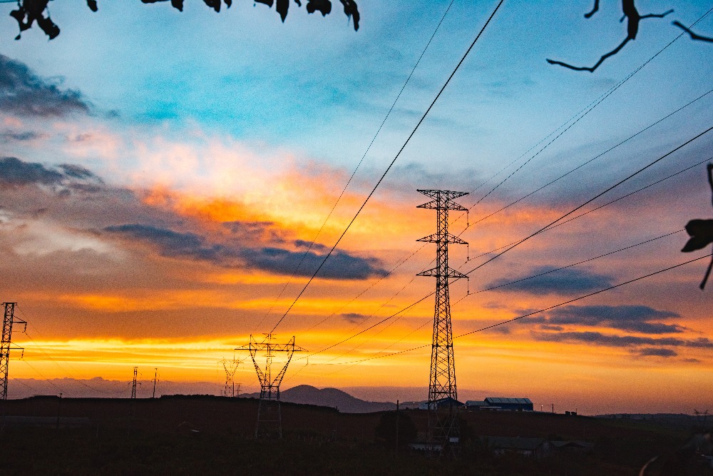 powerlines in a field at sunset