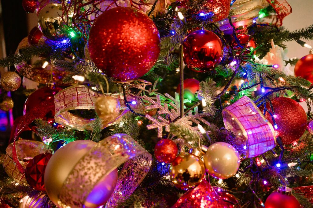 Traditional Christmas tree with colored lights and red ornaments