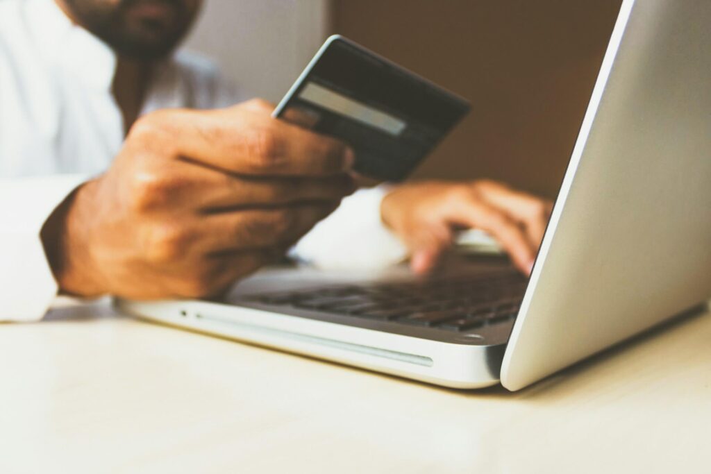 Person using their laptop and holding a credit card